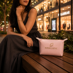 Woman in a black dress sitting on a wooden bench beside a pink MIRACLISTIC female essential kit pouch